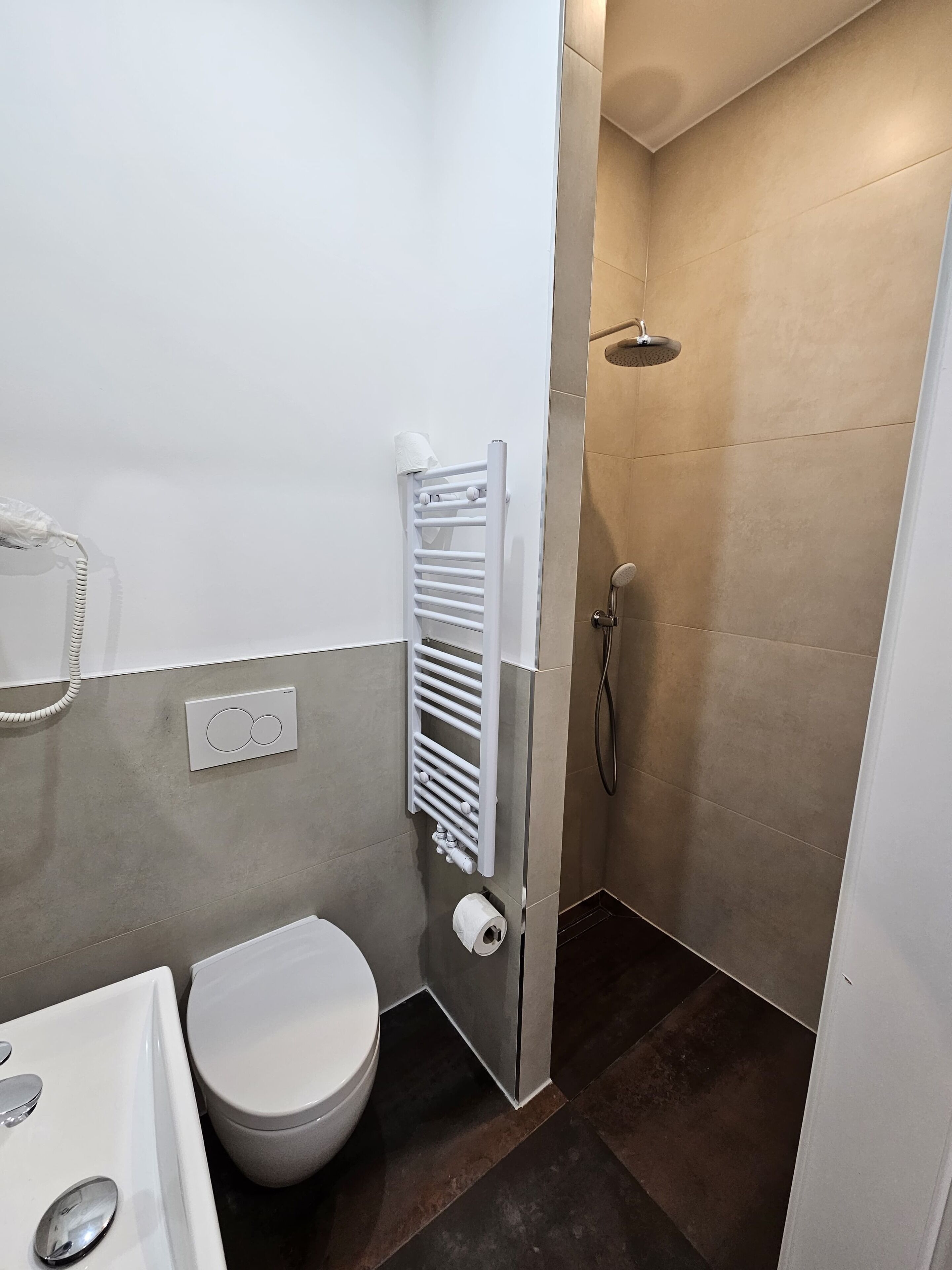 A modern bathroom with a toilet, sink, and shower.