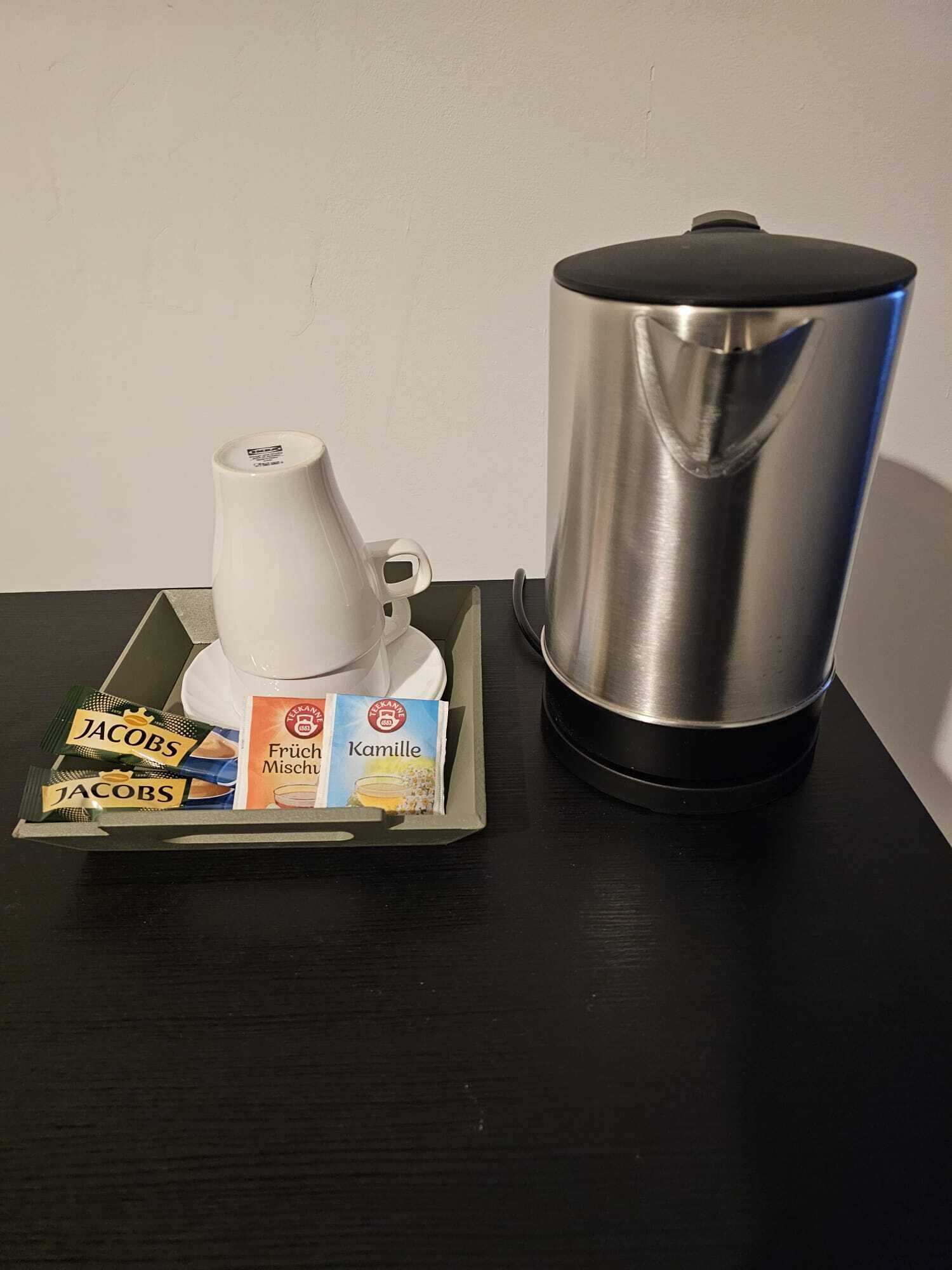 A coffee maker and a tray with coffee pods on a table.