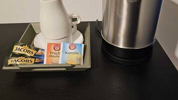 A coffee maker and a tray with coffee pods on a table.