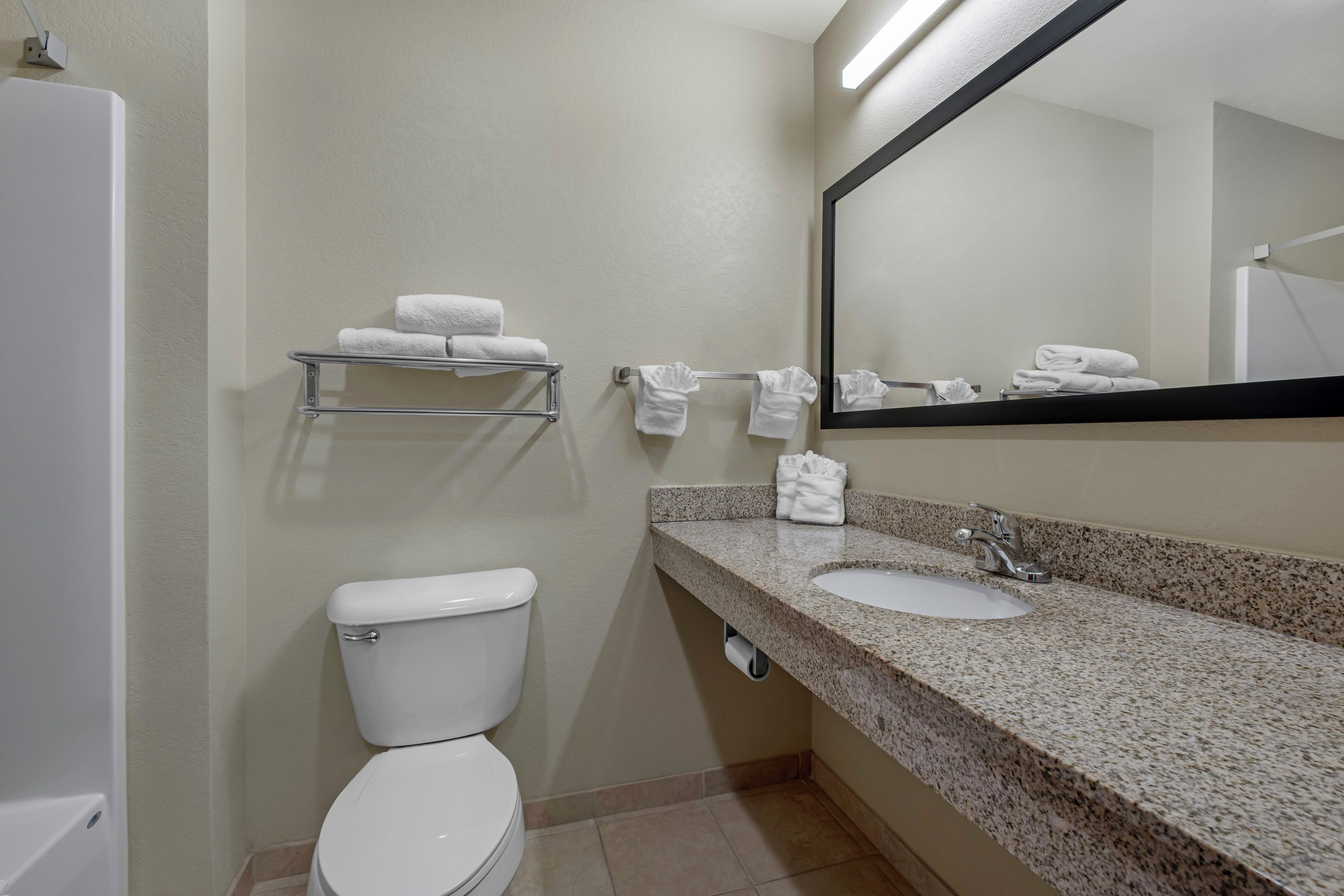 A bathroom with a toilet, sink, and towel rack.