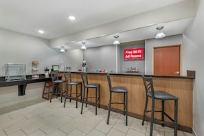 A bar area with a counter, stools, and a sign indicating free Wi-Fi in all rooms.