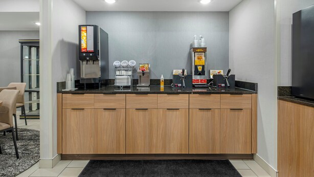 A modern kitchen with a coffee machine, waffle maker, and a refrigerator. - Red Roof Inn Charlestown (Charlestown)