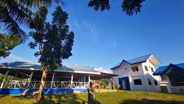 Área residencial com casas, uma construção coberta e uma palmeira.