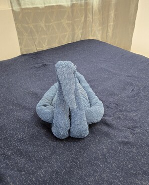 A dark blue textured sofa in a room with a patterned curtain in the background. - B'lu Bamboo - GH.A.RB (Moalboal)