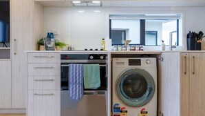 Een kleine keuken met een inbouwoven en een voorlader wasmachine.