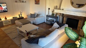 Una sala de estar acogedora con chimenea, televisor y zona de estar confortable.