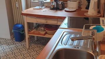 A compact kitchen with a window, a sink, and various kitchen appliances.