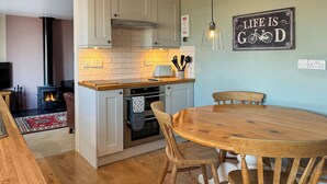 A cozy kitchen with a central island, wooden chairs, and a dining table. - Derwent Cottage - UK49220 (Burythorpe, near Malton)
