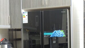 Eine moderne Küche mit Einbaukühlschrank, Backofen und Mikrowelle.