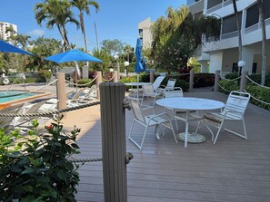 Un espace aménagé au bord de la piscine, avec des chaises longues, une table et des parasols.