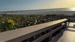 A wooden deck with a view of the beach and ocean. - Top-Floor Partial Gulf View!  Steps from the Beach!  Little Tropical Paradise! (Marco Island)