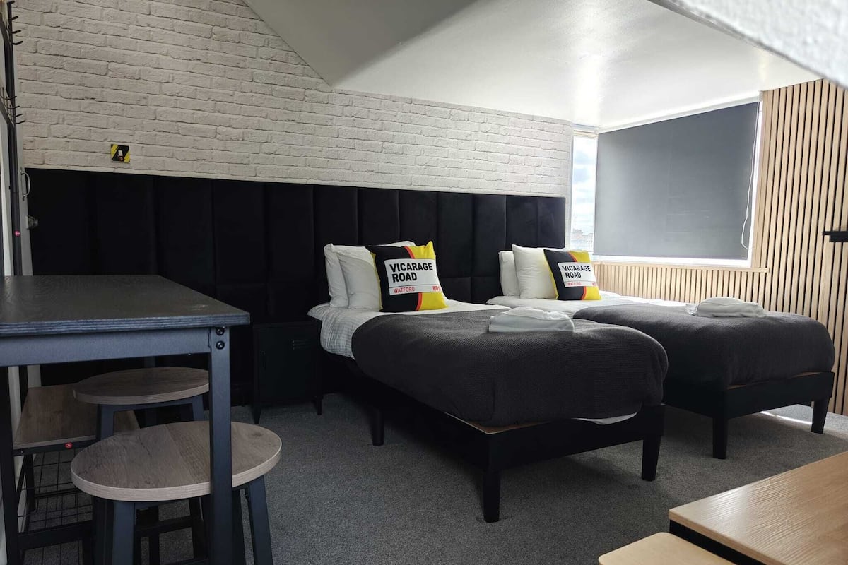 A room with two beds, a desk, and a chair.
