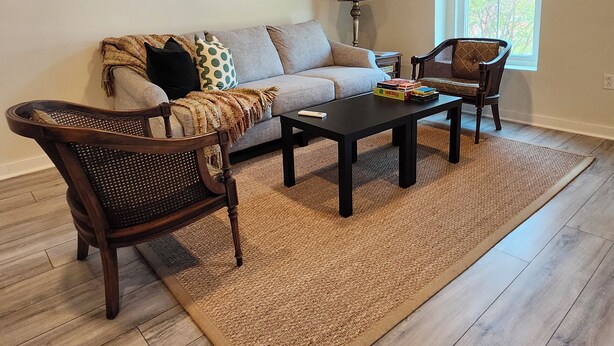 A living room with a sofa, two armchairs, a coffee table, and a lamp. - Modern apartment overlooking historic downtown Elloree, SC. (Elloree)