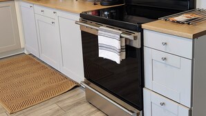 A modern kitchen with stainless steel appliances, a microwave, a coffee maker, and a built-in oven. - Modern apartment overlooking historic downtown Elloree, SC. (Elloree)