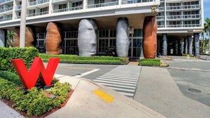 A modern hotel with a distinctive architectural design featuring large, cylindrical columns and a prominent red 'W' logo. - ICON W BRICKELL RENTALS SLEEK STUDIO #2005 (Miami)