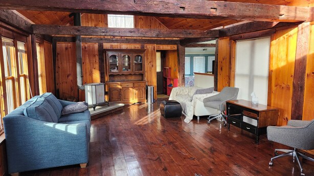 A spacious room with wooden floors, a sofa, a desk, and a chair. - Cabin in the Woods (Franklin)