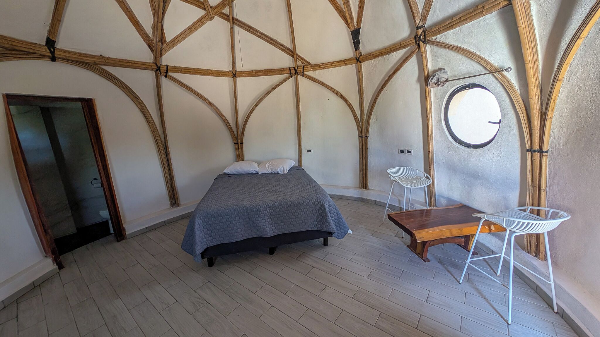 A room with a bed, a small table, and a chair.