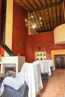 Una habitación con chimenea de ladrillo, lámpara colgante y piso de baldosas.