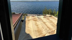 Vista dalla finestra su un corpo d'acqua, con cielo sereno.