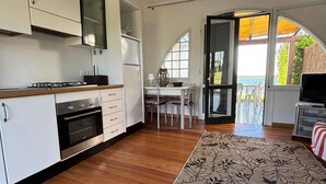 Una cucina moderna con mobili bianchi, forno integrato e zona pranzo con tavolo e sedie.
