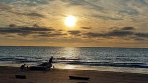 A beach scene with a boat and people at sunset. - Waterfront retreat in Casablanca (Same)