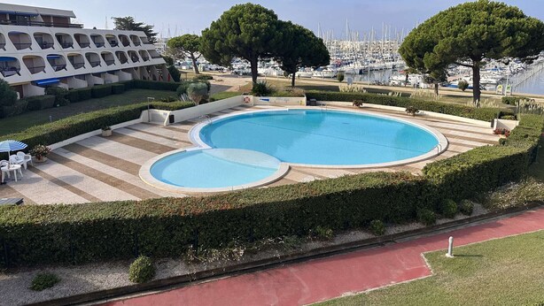 A swimming pool with a view of boats in the background.
