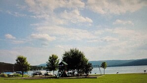 Un parc doté d’une aire de jeux, de tables de pique-nique et offrant une vue sur un lac.