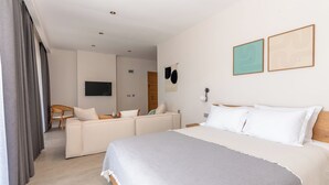 A modern hotel room with a large bed, a sofa, a TV, and artwork on the walls. - Bade Gölcük (Odemis)