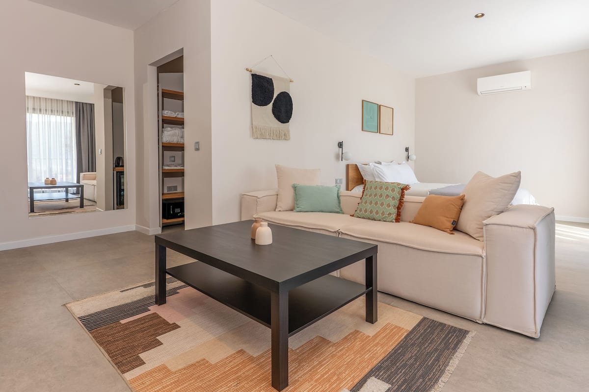Uma sala de estar moderna com sofá, mesa de centro e tapete.