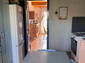 Uma cozinha com geladeira, fogão e armários de madeira.