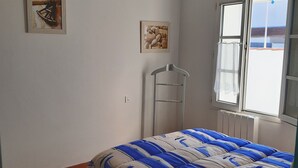 A bedroom with a bed, a window, a radiator, and two paintings on the wall. - Semi-detached house 4 pers, near beach, pets allowed (La Guérinière)