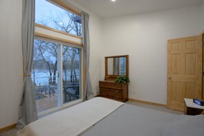 Enjoy a peaceful retreat with a large window offering a view of the outdoors, a dresser, and a mirror.