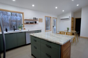 Enjoy meals in this well-lit kitchen and dining area with a dishwasher and comfortable seating.