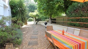 A patio with a table and chairs, surrounded by gravel and plants. - Family cottage between Angers and Saumur (Blaison-Saint-Sulpice)