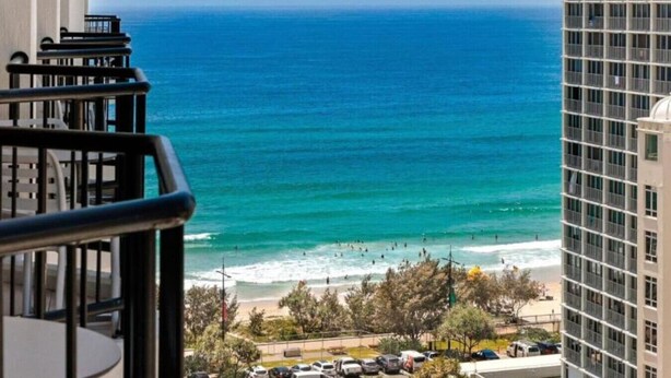 A view of the ocean from a balcony with a building in the foreground. - Ocean & City Views, Level 17, 5GInternet At Mantra (Surfers Paradise)