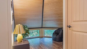 A room with a wooden ceiling, a lamp, a plant, a bean bag, and a view through a window. - Play Arcade Games, Make Firepit S'mores & Explore Downtown Blue Ridge in Minutes - Trails End (Blue Ridge)