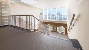 A spacious interior with a staircase, large windows, and a skylight. - Rynek Wrocław Luminous Apartment (Wroclaw)