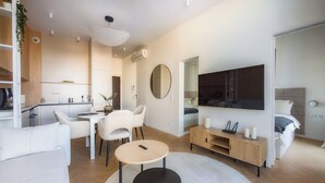 A modern, well-lit living room with a sofa, a round coffee table, and a TV mounted on the wall. - Rynek Wrocław Luminous Apartment (Wroclaw)