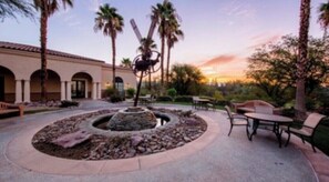 Relax in a serene outdoor space surrounded by lush greenery and a central fountain.