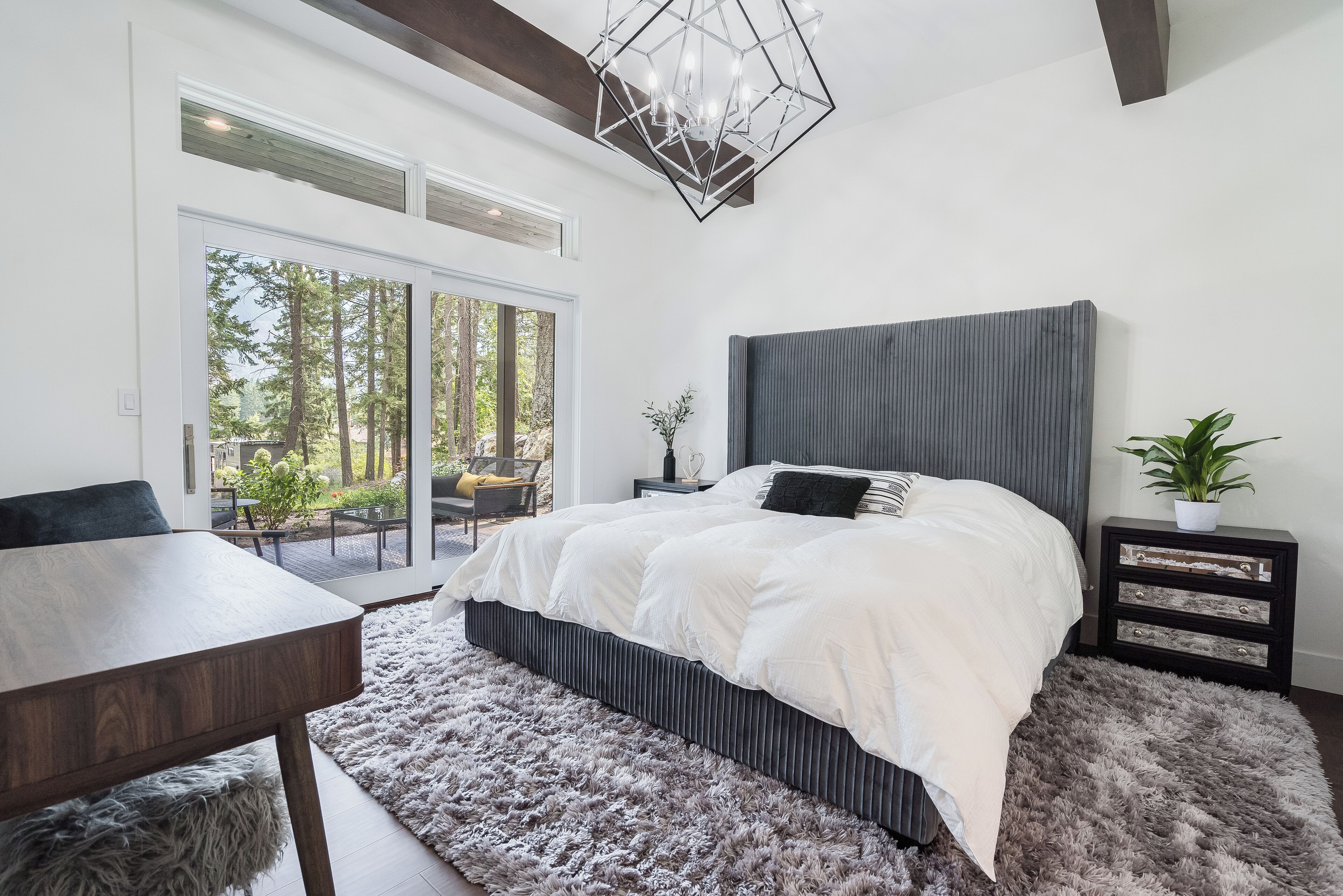 Ein Schlafzimmer mit einem großen Bett, einem Esstisch und Blick ins Freie.