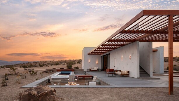 A modern outdoor patio with a pool, seating, and a pergola structure.