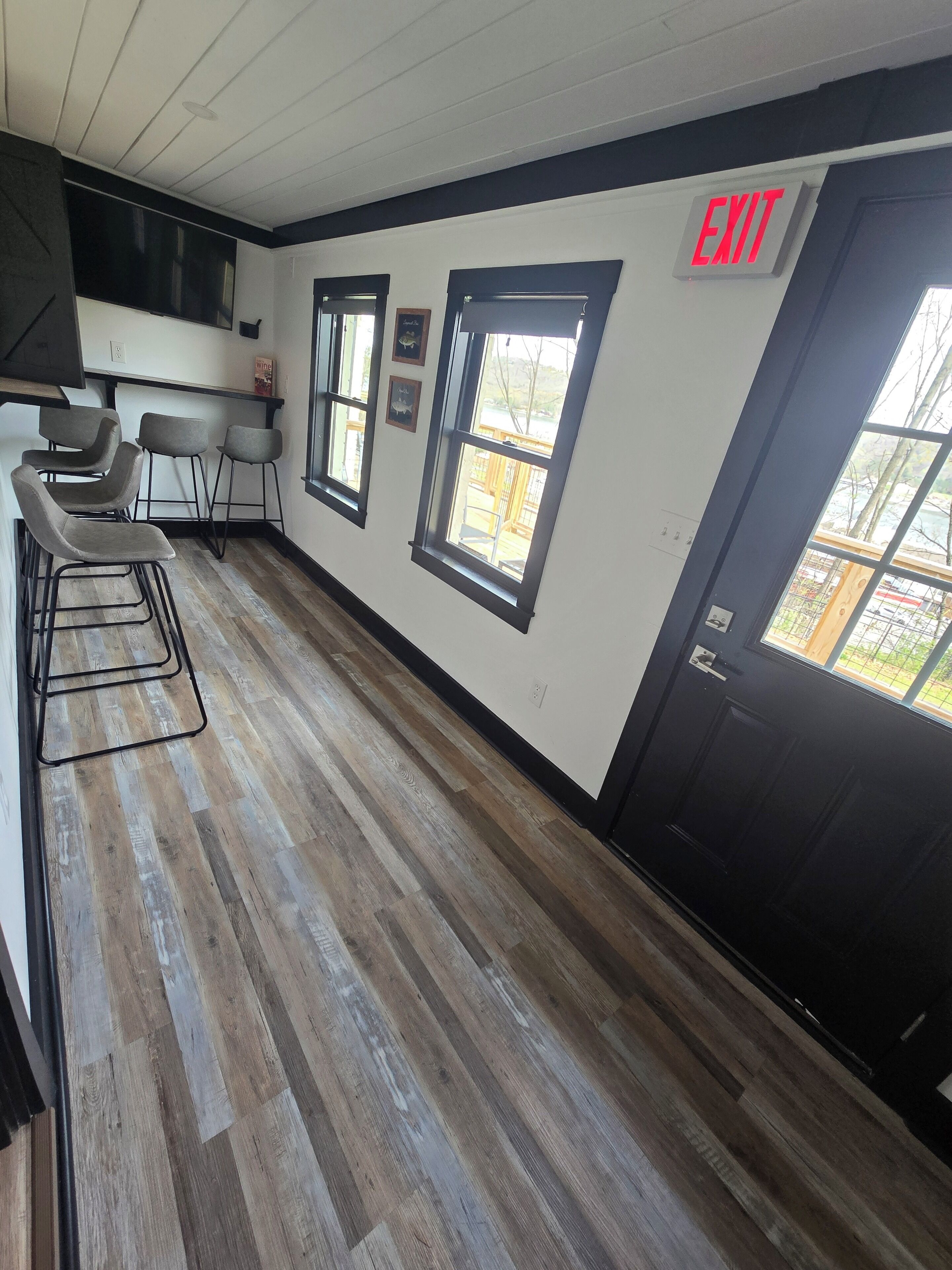 Una cucina moderna in bianco e nero, con pavimento in legno e sgabelli da bar.