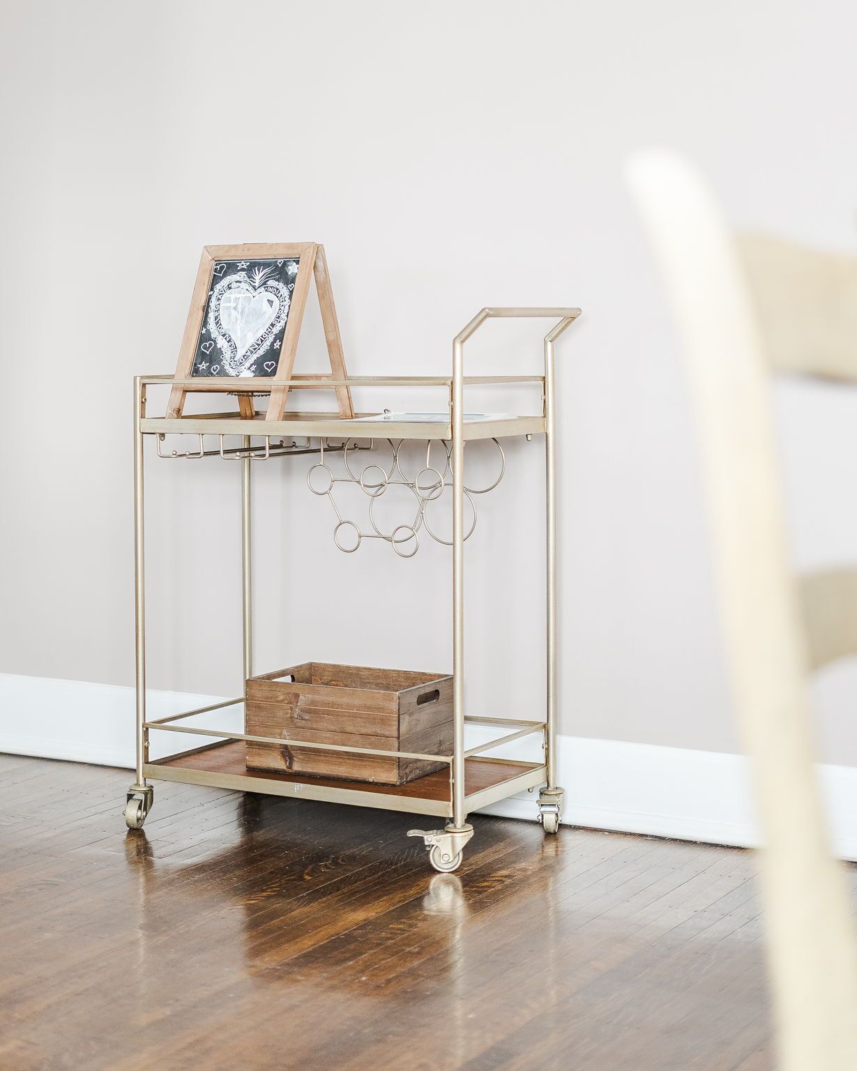 A metal cart with a wooden crate and a chalkboard with heart designs.