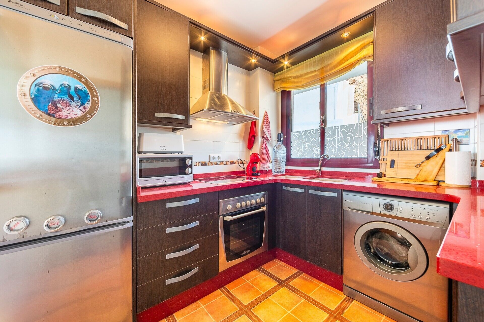 Cocina compacta equipada con microondas, horno y lavadora.