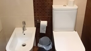 Ein Badezimmer mit einer Bio-Toilette, Waschbecken und einem Handtuchhalter.