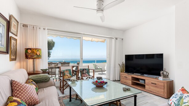 A living room with a TV, sofa, and dining area with a view. - Apartment 'Del Mar' with Sea View, Wi-Fi and Air Conditioning (Marbella)