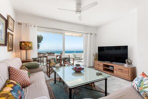 Ein Wohnzimmer mit Fernseher, einer Couch und einem Essbereich mit Blick.