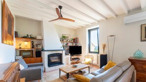 A living room with a fireplace, sofa, coffee table, and a television. - Holiday Home 'Le Sophora' with Mountain View, Wi-Fi and Air Conditioning (ROCHEFORT DU GARD)