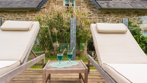 A wooden deck with two lounge chairs and a table with two glasses of blue drink. - Guest Room 'Magnolia' with Shared Pool, Shared Terrace, and Wi-Fi (Arzano)