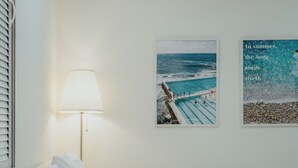 Ein Hotelzimmer mit einem Bett, einer Lampe und zwei gerahmten Bildern an der Wand.